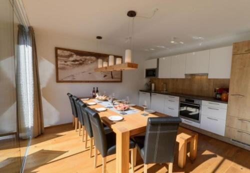 uma sala de jantar com uma mesa de madeira e cadeiras em Apartment am Sonnenhang Top 6 em Neukirchen am Grossvenediger