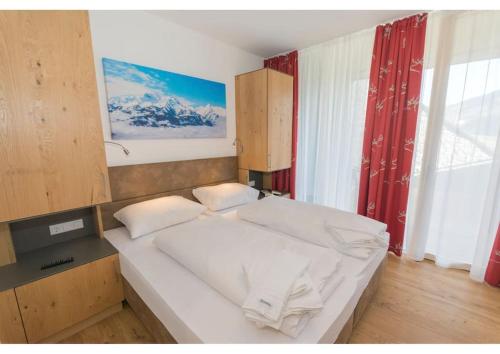 ein Schlafzimmer mit einem weißen Bett in einem Zimmer in der Unterkunft Apartment am Sonnenhang Top 6 in Neukirchen am Großvenediger
