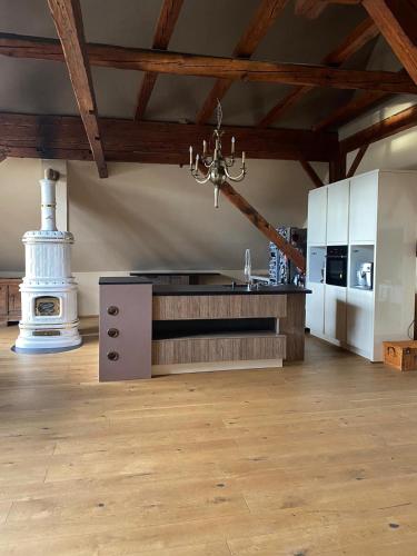 a kitchen with white cabinets and a chandelier in a room at Altbauwohnung mit Fachwerk in Anif