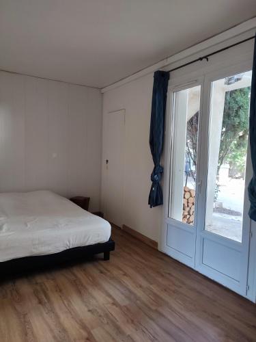 een slaapkamer met een bed en een groot raam bij Suite privée in Montélimar