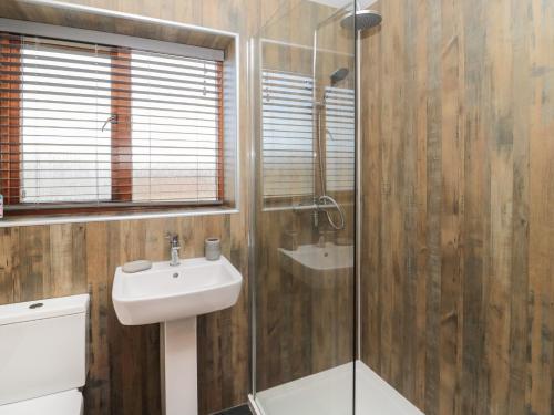 a bathroom with a sink and a glass shower at Causeway Cottage in Berwick-Upon-Tweed