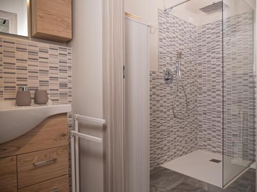 La salle de bains est pourvue d'une douche avec une porte en verre. dans l'établissement Casa Patty, à Desenzano del Garda