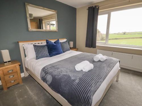 a bedroom with a bed with two towels on it at Coedfan in Ruthin