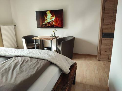 a room with a bed and a table with a fireplace at Gasthaus Herrig in Meckel
