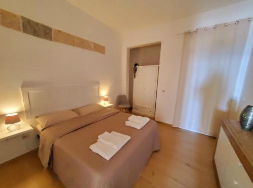 ein Schlafzimmer mit einem großen Bett mit zwei Handtüchern darauf in der Unterkunft SEA FRONT, Allegria, Santa Maria al Bagno in Nardò