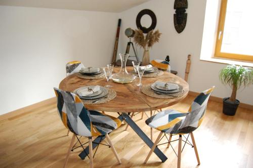 uma mesa de madeira com cadeiras e uma sala de jantar em Le Montferrand - Jules Guesde Appartement rénové lumineux em Clermont-Ferrand