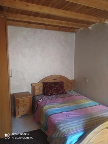 um quarto com uma cama com uma cabeceira de madeira em N42 Residence Amine em Ifrane
