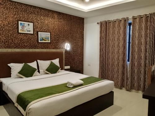 a bedroom with a large bed and a window at Hotel Greenlife in Cochin