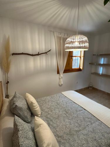 a bedroom with a large bed and a chandelier at RentitSpain Puerta de la Ragua in Picena