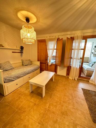 - un salon avec un lit et une table dans l'établissement RentitSpain Puerta de la Ragua, à Picena