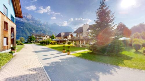 an empty street in a house with mountains in the background at Walensee House & Apartments in Unterterzen