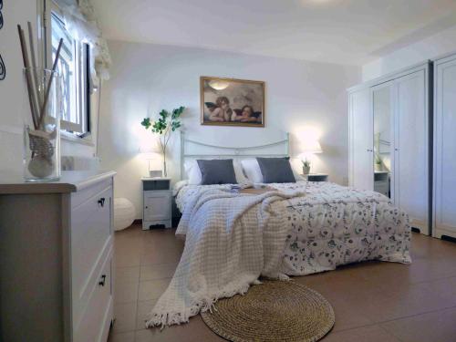 a white bedroom with a bed and two lamps at Residence Valeria in Cervia