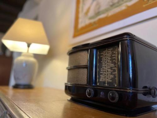 a radio sitting on a table next to a lamp at A Funtanella, maison de caractere situe entre montagne et mer in Tavera