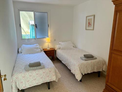 two beds in a room with a window at Casa Lube in Corralejo