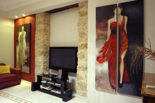 un soggiorno con un dipinto di una donna sul muro di Abatellis Luxury a Palermo