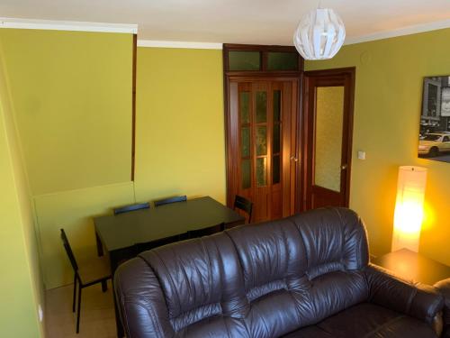 a living room with a leather couch and a table at La Buhardilla De Solavega - VV2530AS in Sevares