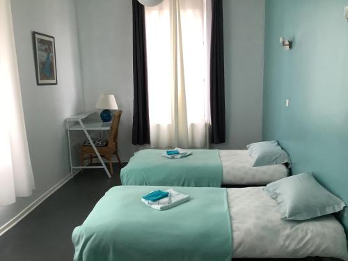 ein Hotelzimmer mit 2 Betten und Handtüchern darauf in der Unterkunft Le Sarment in Sainte-Menehould