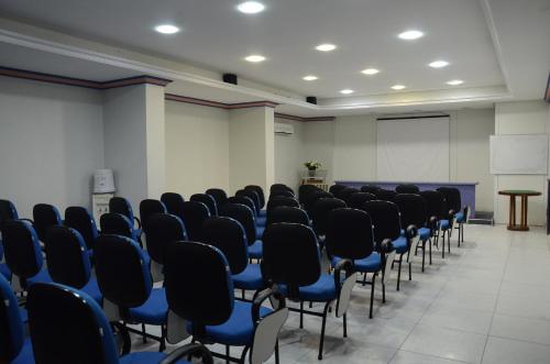 ein Zimmer mit Sitzreihen und einem Podium in der Unterkunft Titão Plaza Hotel in Campina Grande