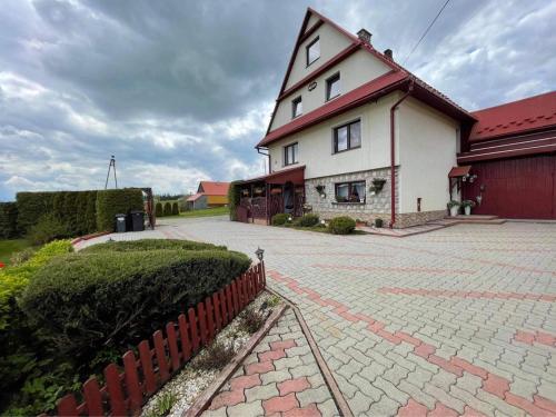 a large white house with a red roof at Agroturystyka Pod Dzwonnicą - Beskidy in Zubrzyca Górna