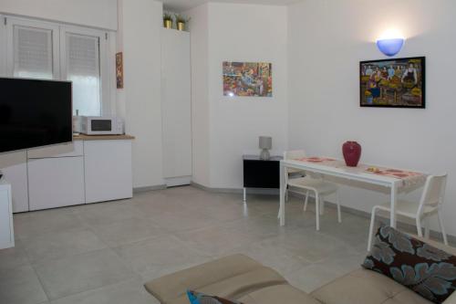 a white living room with a table and a tv at Torre San Bonifacio - Locazione Turistica in San Bonifacio