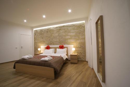 a bedroom with a large bed with red roses on it at Boscò Suites in Carini