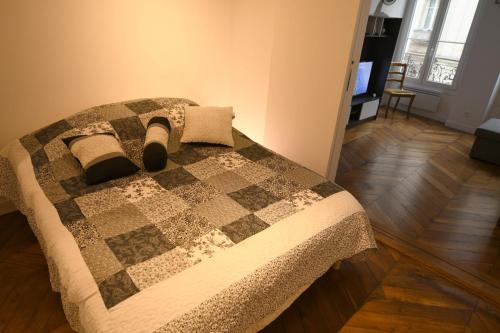 a bedroom with a bed with a quilt on it at Orléans in Paris