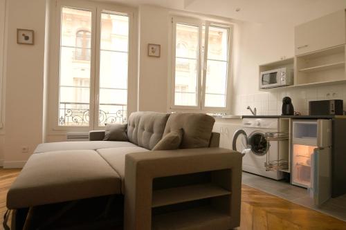 a living room with a couch and a kitchen at Orléans in Paris