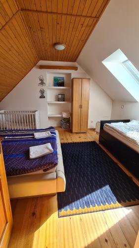 a attic room with two beds and a rug at Chalupa u rybára s Wellness a detským ihriskom in Liptovský Trnovec