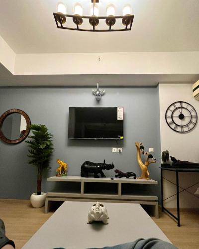 a living room with a tv and some animals on a shelf at The Nest Lucknow in Lucknow