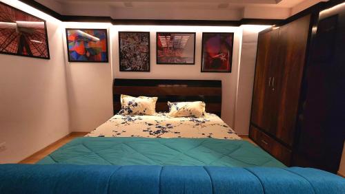 a bedroom with a bed and some pictures on the wall at The Nest Lucknow in Lucknow