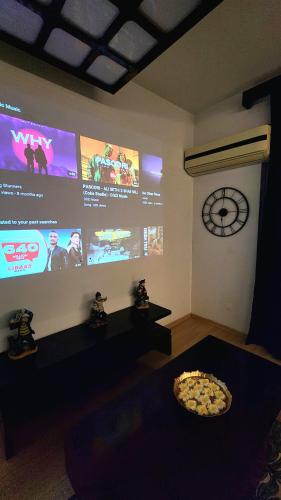 a room with a large screen with a pizza on a table at The Nest Lucknow in Lucknow