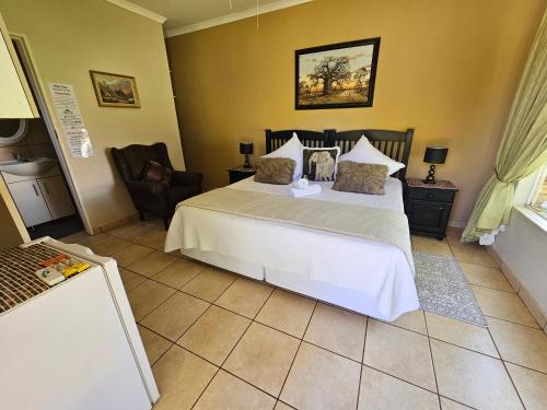 a bedroom with a large white bed in a room at Aloetree Cloves room in Krugersdorp