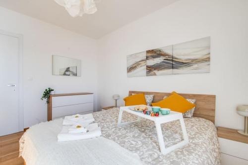 un dormitorio blanco con una cama con una mesa encima en A terrace on the lake of Lugano, en Aldesago