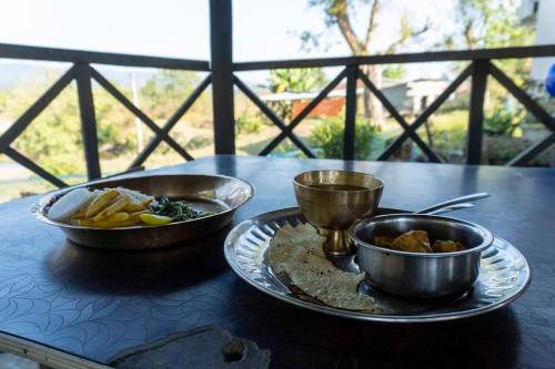 una mesa con dos platos de comida en una mesa en Ayodhyapuri Community Homestay, en Chitwan