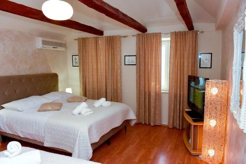 a bedroom with a bed and a flat screen tv at Apartment Baćo in Split