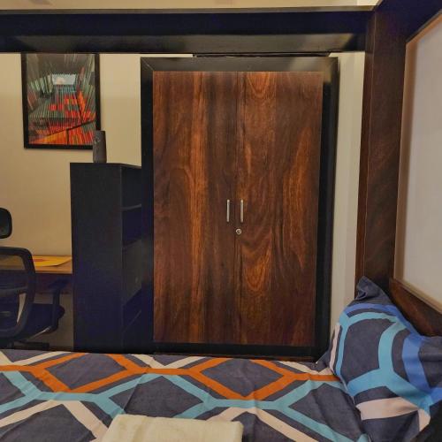 a wooden door in a bedroom with a bed at The Nest Lucknow in Lucknow