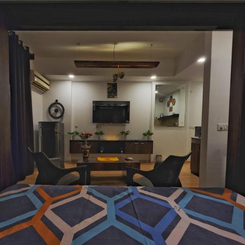 a living room with a couch and chairs and a tv at The Nest Lucknow in Lucknow