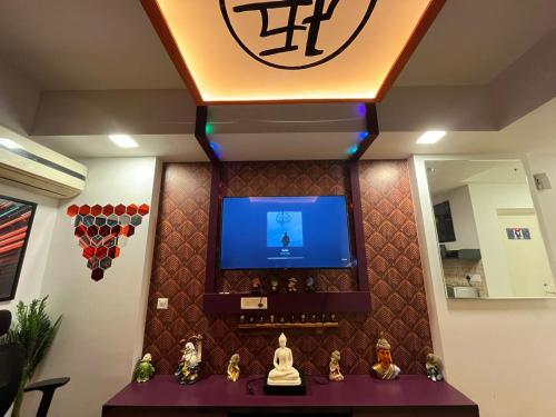 a room with a tv and a wall with a mirror at The Nest Lucknow in Lucknow