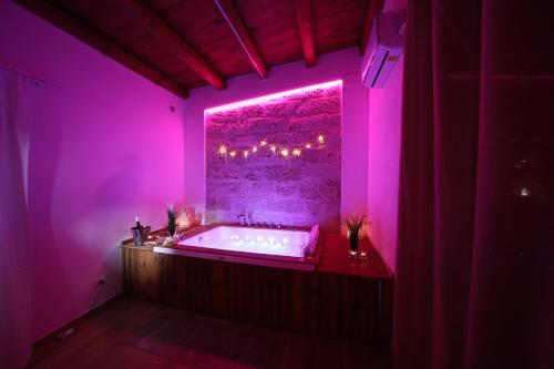 a purple bathroom with a tub with a pink lighting at Boscò Suites in Carini