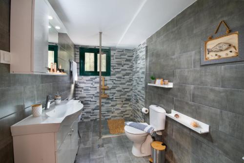 uma casa de banho com um lavatório e um WC. em Vive Mar Paxos em Gaios