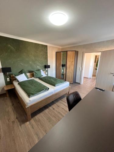 ein Schlafzimmer mit einem großen Bett und einem Tisch in der Unterkunft Gasthof Seeklause in Pfedelbach
