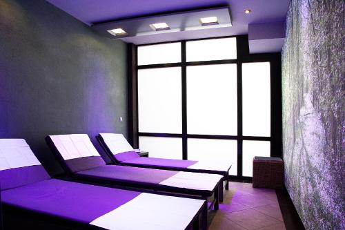 a room with purple chairs and a large window at MUNTE - Wellnesshotel am Stadtwald in Bremen