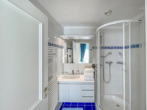 ein weißes Bad mit einer Dusche und einem Waschbecken in der Unterkunft Forum Luxury Apartment Lake View in Montreux