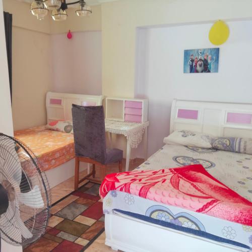a bedroom with two beds and a table and a chair at Flores casas de playa in Alexandria