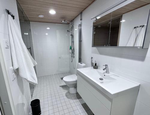 a white bathroom with a sink and a toilet at Peaceful Premium Apartment with Sauna and Balcony - Perfect Downtown Location in Tampere