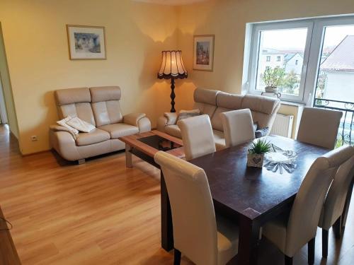 a living room with a table and chairs and a couch at Apartament GórnyŚląsk blisko jeziora - 120qm - 3 sypialnie z parkingiem i klimatyzacją - Flat UpperSilesia with Parking & air conditioning - Ferienwohnung OberSchlesien mit 3 Schlafzimmern inklusive Parkplatz und Klima - Nähe Badesee und Sandstrand in Niewiesze