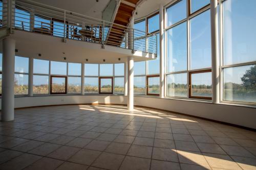 an empty room with large windows in a building at Hotel Caneo in Fossalòn