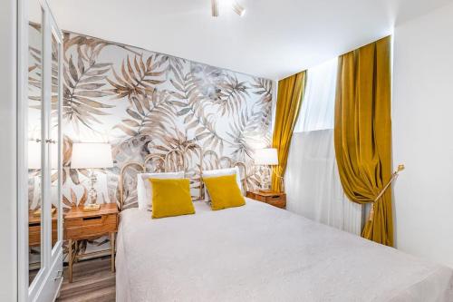 a bedroom with a white bed with yellow pillows at Urban style 3-bedroom apartment in Montreux
