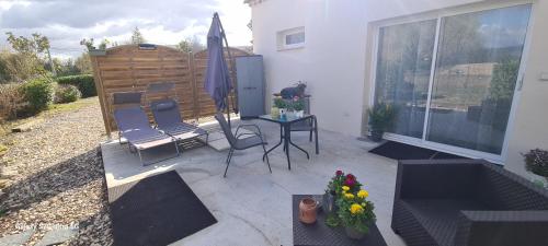 a patio with chairs and an umbrella and a table at MAS GABELYS superbe vue SAINTE VICTOIRE jardin terrasse et piscine in Trets