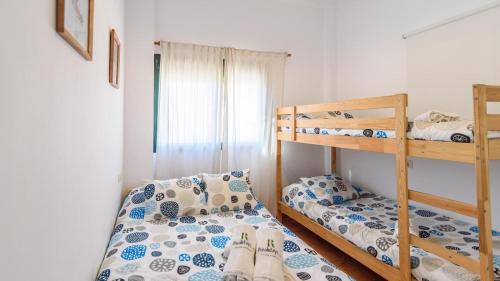 a bedroom with two bunk beds and a window at Casa Cerrito Prado del Rey by Ruralidays in Prado del Rey